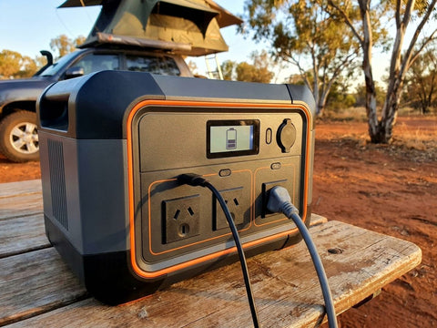 A portable power station running a camp fridge and lights at an outback campsite