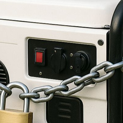 Daytime photo of a portable generator secured with a chain and brass padlock against a light gray wall.