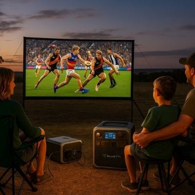 Family watching outdoor sports screen powered by Bluetti power station