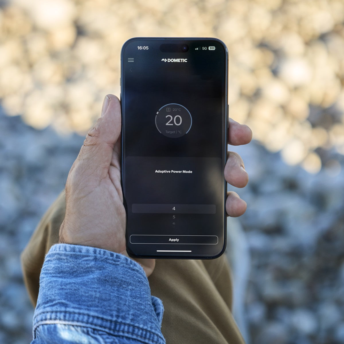 Hand holding a phone running the Dometic app set to 20 degrees