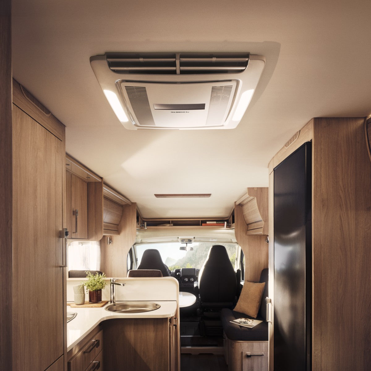Motorhome interior looking forward past the ceiling ADB to the kitchen and cab seats