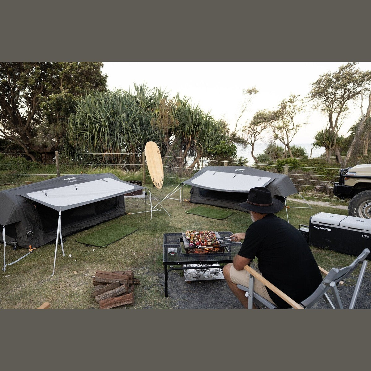Pico FTC 2x2 swags pitched at a campsite with a bloke cooking at the table