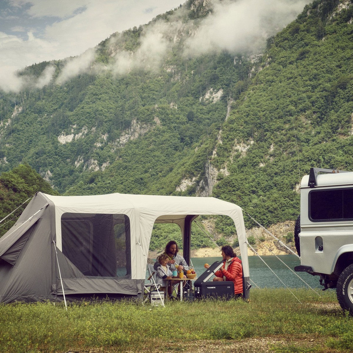 Santorini FTK 4x8 pitched beside a van in a mountain valley with a couple seated outside