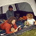 Dad and two kids lying inside the Reunion tent reading together