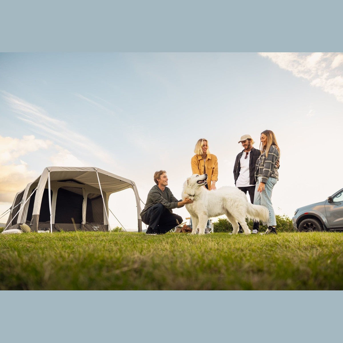 Group with a dog relaxing beside the Santorini FTK 2x4 in a field at sunset