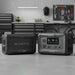 Dark grey portable generators compatible with each other lying on the ground.