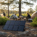 Bluetti SORA130 Solar Panel 130W at a campsite with campers in the background.