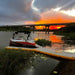 Bartlett Y-shaped inflatable pontoon offering a scenic view of a vibrant sunset over a river and bridge