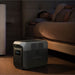 Portable power station running quietly beside a sleeping man in a bedroom.
