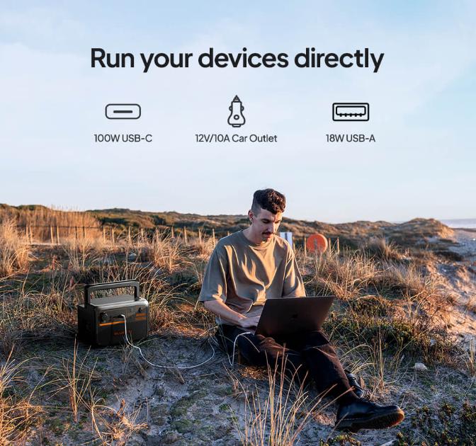 Man using laptop powered by Bluetti B80P battery on the beach