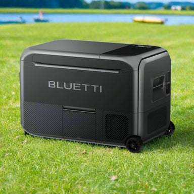 Bluetti portable camping fridge on grass near water.