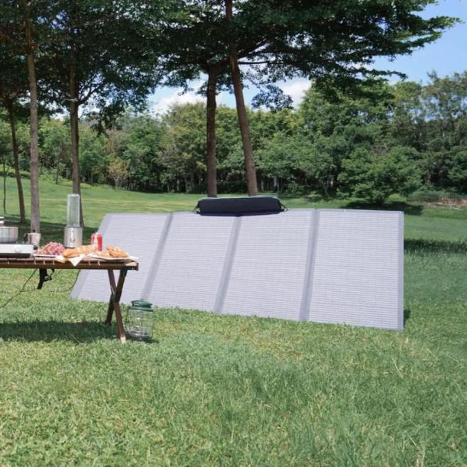 Solar panel set up beside picnic table in grassy park