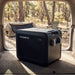 Dometic CFX5 25 portable fridge freezer in the open rear of a station wagon at a bush campsite in early morning light