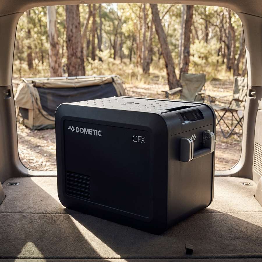 Dometic CFX5 25 portable fridge freezer in the open rear of a station wagon at a bush campsite in early morning light