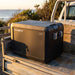 Dometic CFX5 45 portable fridge freezer in the open tray of a dual cab ute at a coastal campsite at golden hour