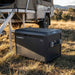 Dometic CFX5 55 portable fridge freezer on the grass beside a camper trailer awning in the high country