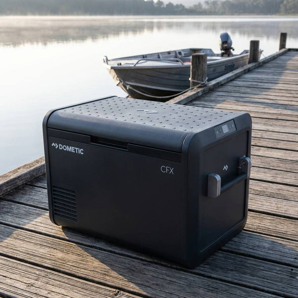 Dometic CFX5 55IM portable fridge freezer on a timber jetty beside a moored tinnie at first light