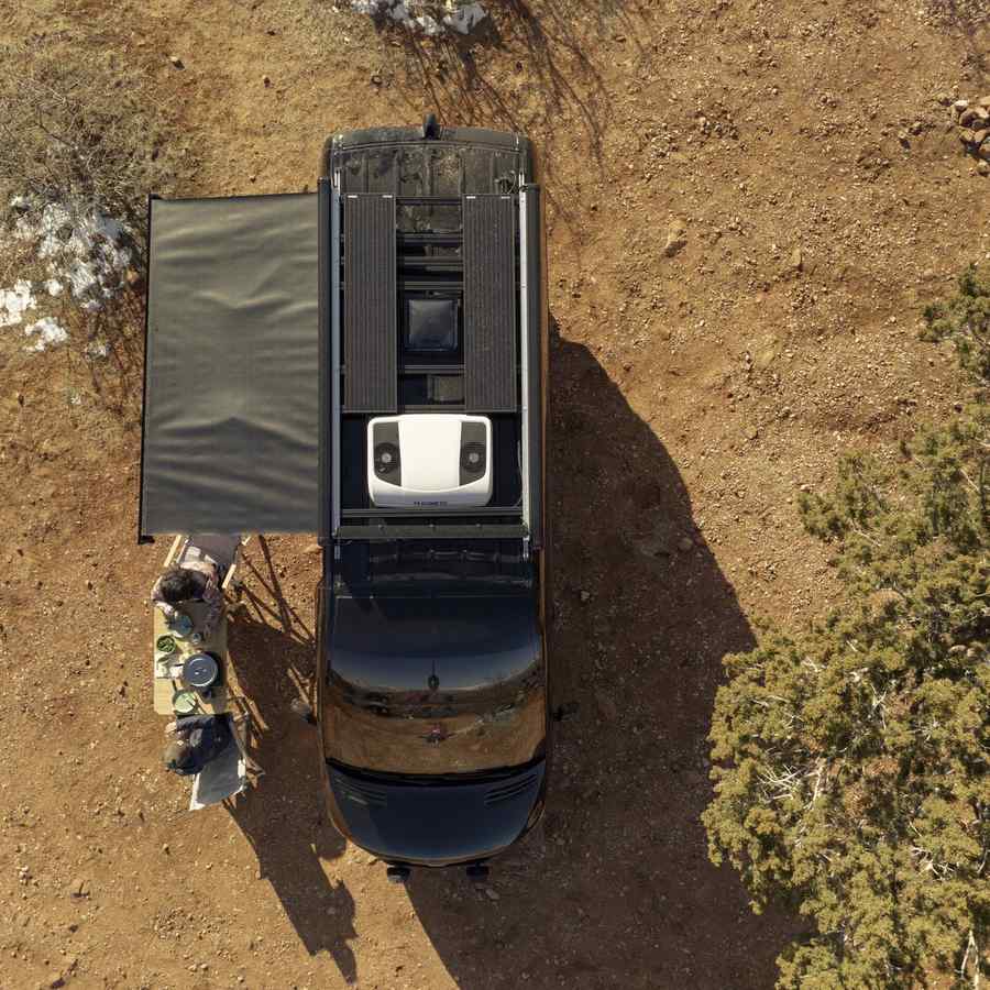 Overhead view of a four wheel drive with an awning out on red dirt, a Dometic CoolAir RTX unit on the roof