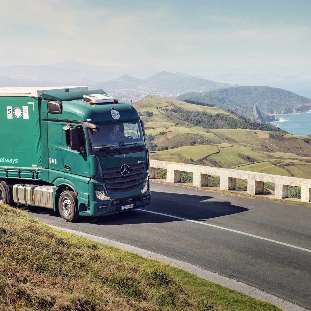 Prime mover on a coastal highway with a Dometic CoolAir RTX parking cooler mounted on the sleeper cab roof