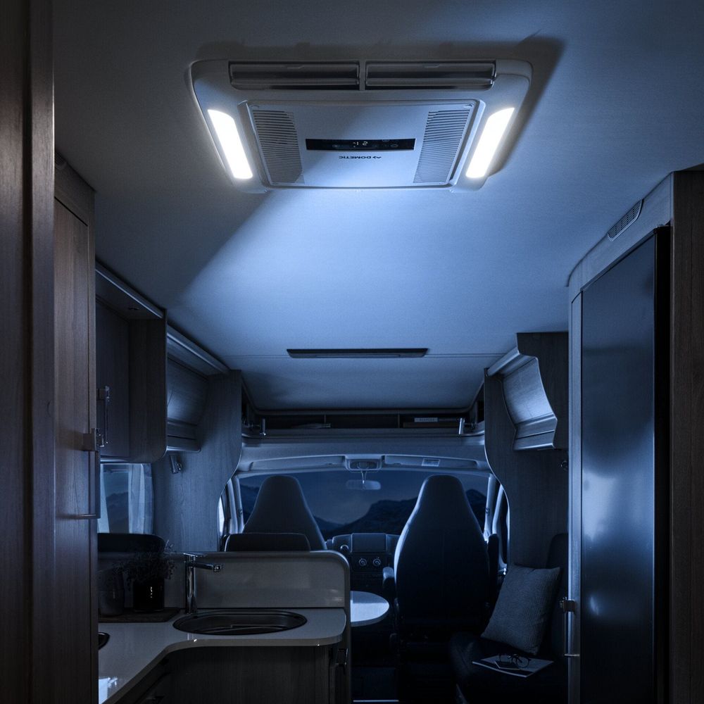 Motorhome interior at night lit by the LEDs in a Dometic air distribution box set into the ceiling