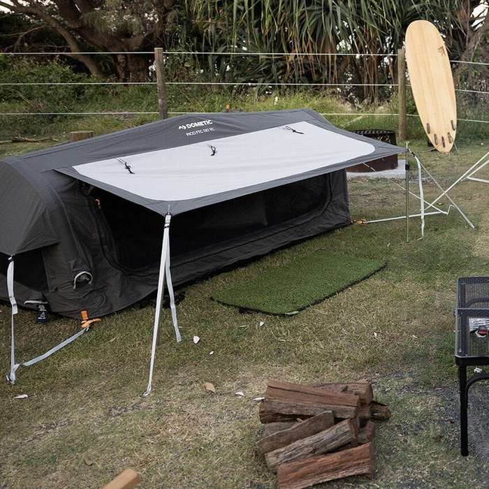 Dometic Pico FTC 1x1 TC-I pitched with the awning up at a coastal campsite beside a fire and firewood