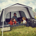 Dometic Reunion FTG 5x5 Redux pitched on grass with a family sitting inside the open front doorway