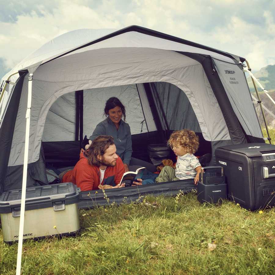 Dometic Reunion FTG 5x5 Redux pitched on grass with a family sitting inside the open front doorway