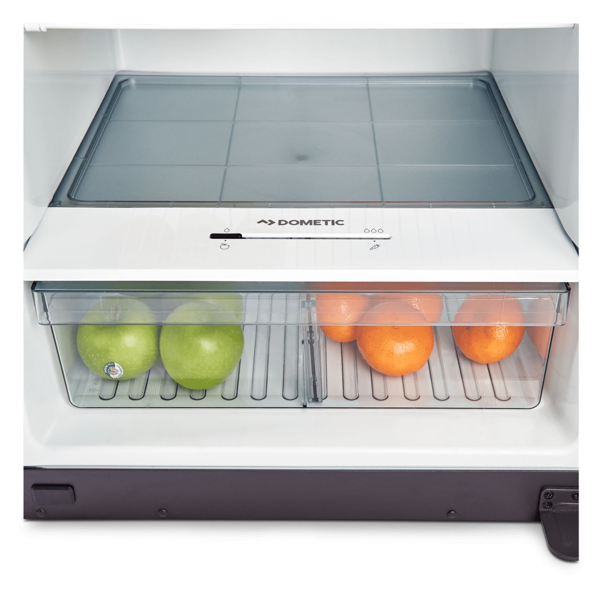 Full-width crisper drawer holding apples and oranges inside a Dometic RUC 6408X