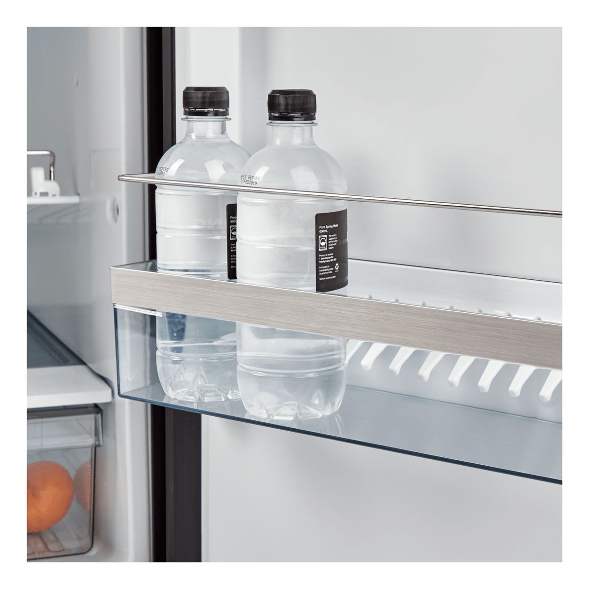 Door rack holding two water bottles behind a retaining bar in a Dometic RUC 8408X
