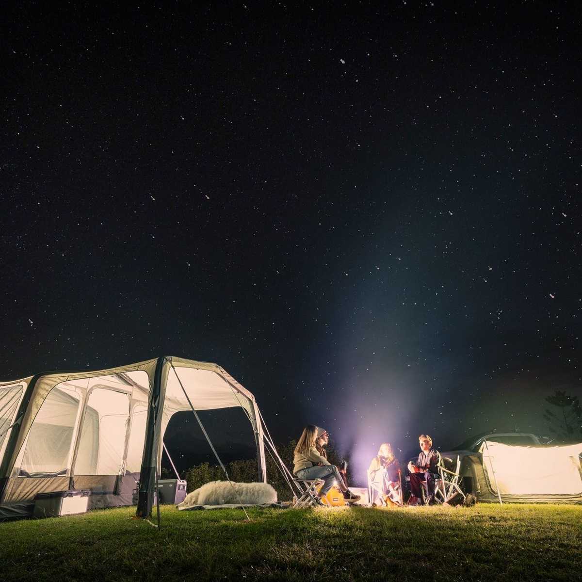 Dometic Santorini FTK 2x4 TC lit from inside at night with a campfire and a second tent alongside