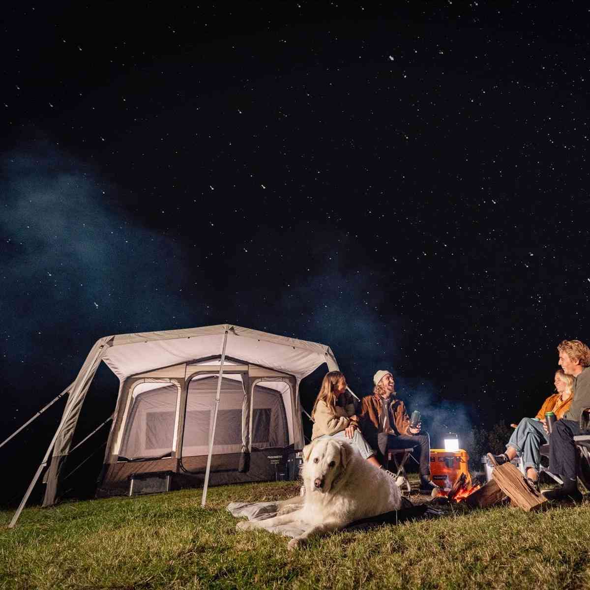 Dometic Santorini FTK 4x8 TC lit from inside at night with a family around a campfire