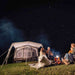 Dometic Santorini FTK 4x8 TC lit from inside at night with a family around a campfire