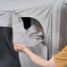 Hand lifting the sidewall panel away from the tent to open the canopy side