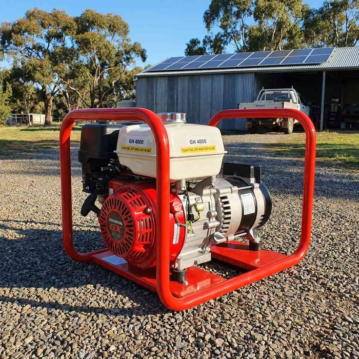 Genelite GH4000-AVR 4.5kVA generator on a gravel driveway at a rural off-grid property with a solar panel array on the shed roof behind