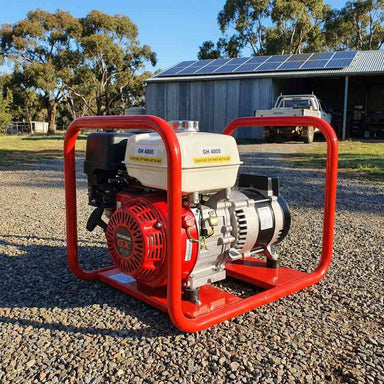 Genelite GH4000-AVR 4.5kVA generator on a gravel driveway at a rural off-grid property with a solar panel array on the shed roof behind