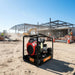 Gentech EP11000HSRE Honda powered generator with electric start operating on an active construction site, showing rugged frame and heavy-duty design.