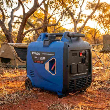 Hyundai HY3500i inverter generator at an Australian bush campsite at golden hour next to a swag and camp chair