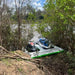 Inflatable dual jetski dock by the riverbank surrounded by trees