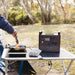 Cooking bacon and eggs on a portable stove powered by the myCOOLMAN 1920Wh power station at a camp table