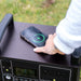 A phone charging wirelessly on top of the myCOOLMAN 1920Wh power station outdoors
