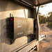 Renogy 104Ah Super Slimline battery mounted flat against a 4WD canopy wall with vibration-resistant brackets