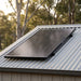 Renogy 120W ShadowFlux solar panel mounted on a rural shed roof in early morning light