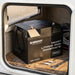 Renogy Pro 100Ah battery sitting in a compact caravan storage locker with cable lugs and a spanner beside it