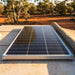 Renogy 175W N-Type solar panel mounted on a camper trailer roof beside a rolled canvas awning