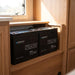 Two Renogy Core Mini 100Ah LiFePO4 batteries fitted in a caravan wall cabinet during a 200Ah kit install