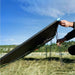 Hand setting up Renogy 220W portable solar panel with kickstand outdoors