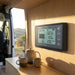 Renogy battery monitor mounted on a van conversion wall above the bench, kettle and mugs nearby