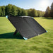 Renogy 120W portable solar panel propped upright on grass.