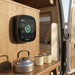 ONE Core mounted above the bench in a van conversion with a kettle and enamel mugs below
