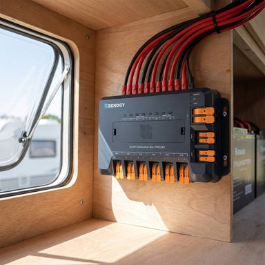 Renogy PMS1260 distribution box mounted inside a caravan locker with red and black cable into the orange lever terminals